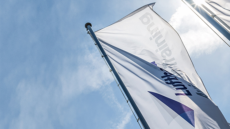 Eine Fahne mit dem Logo von Lufthansa Aviation Training weht im Wind