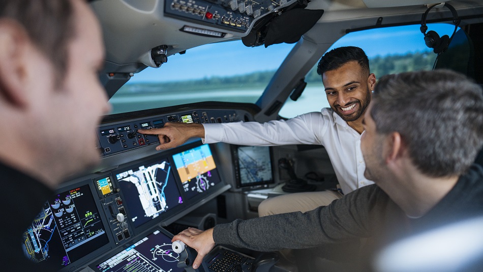 Drei Personen im Cockpit eines Flugsimulators