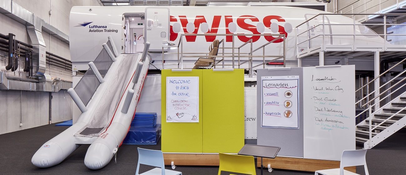 In the foreground, Dancing Walls with workshop materials; in the background, a CEET with SWISS branding inside a hall.