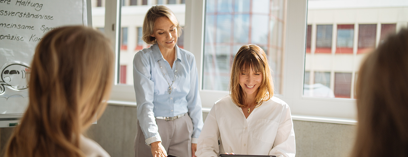 Drei Personen sitzen in einem Meetingraum und machen einen Workshop.